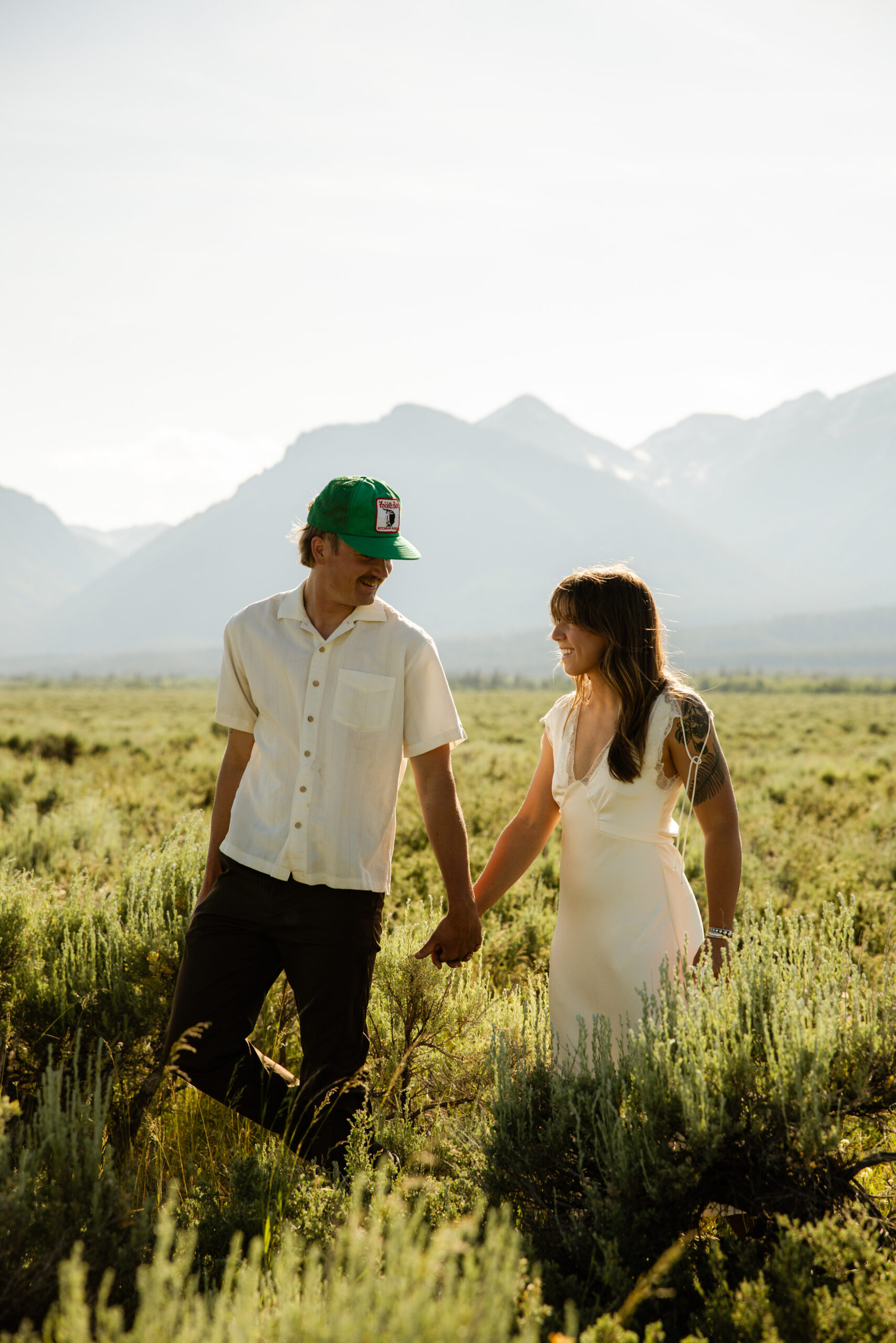 Engaged couple snuggled in the mountains wearing cozy layers for a destination shoot