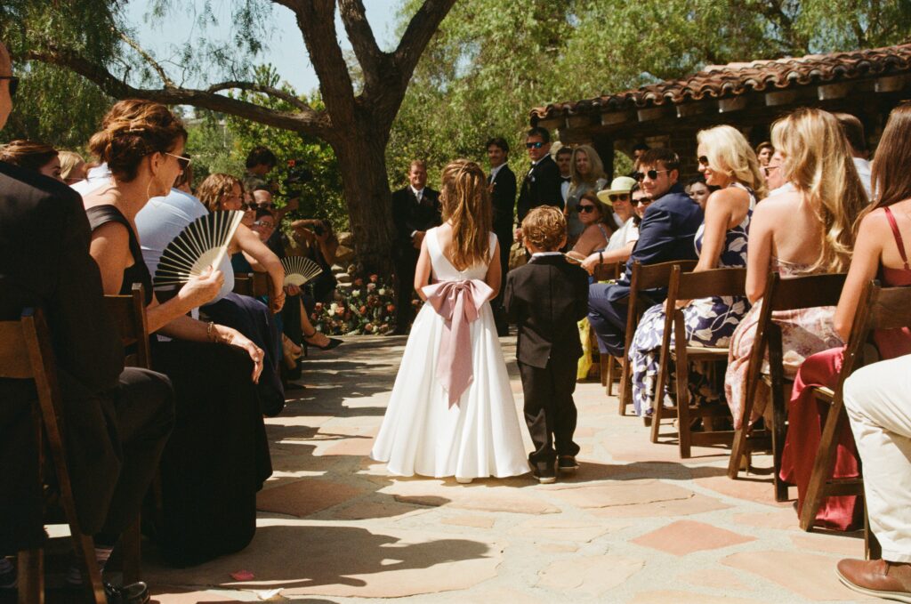 Flower girl and ring bearer walking down the aisle at Grace and Charlie’s wedding in Carlsbad, California.
