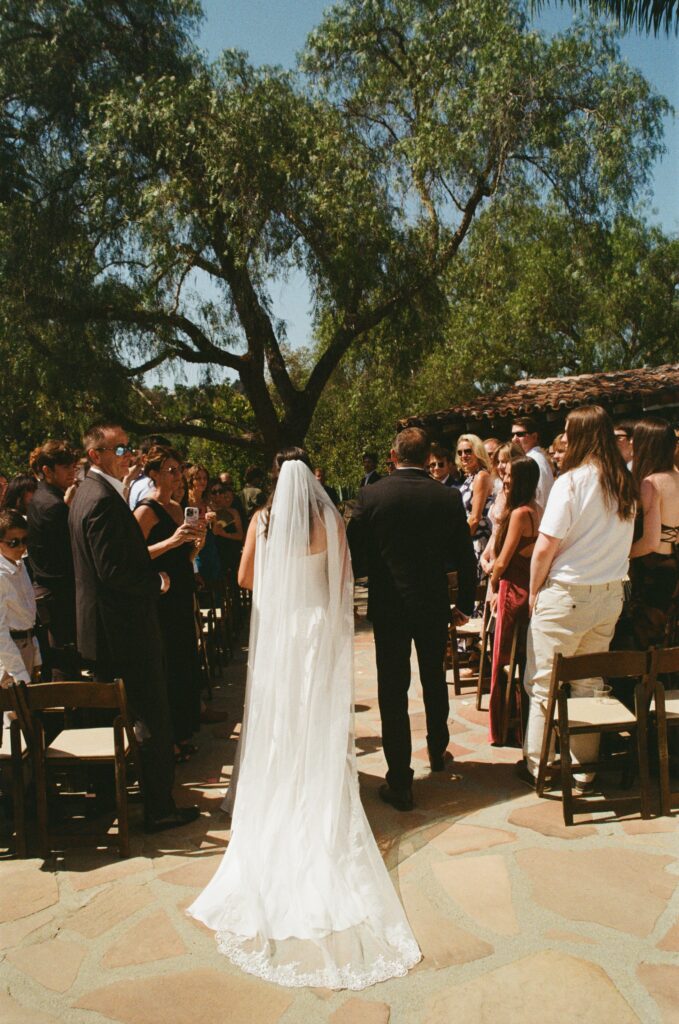 Father walking Grace down the aisle at Leo Carillo Ranch during their sweet California wedding.