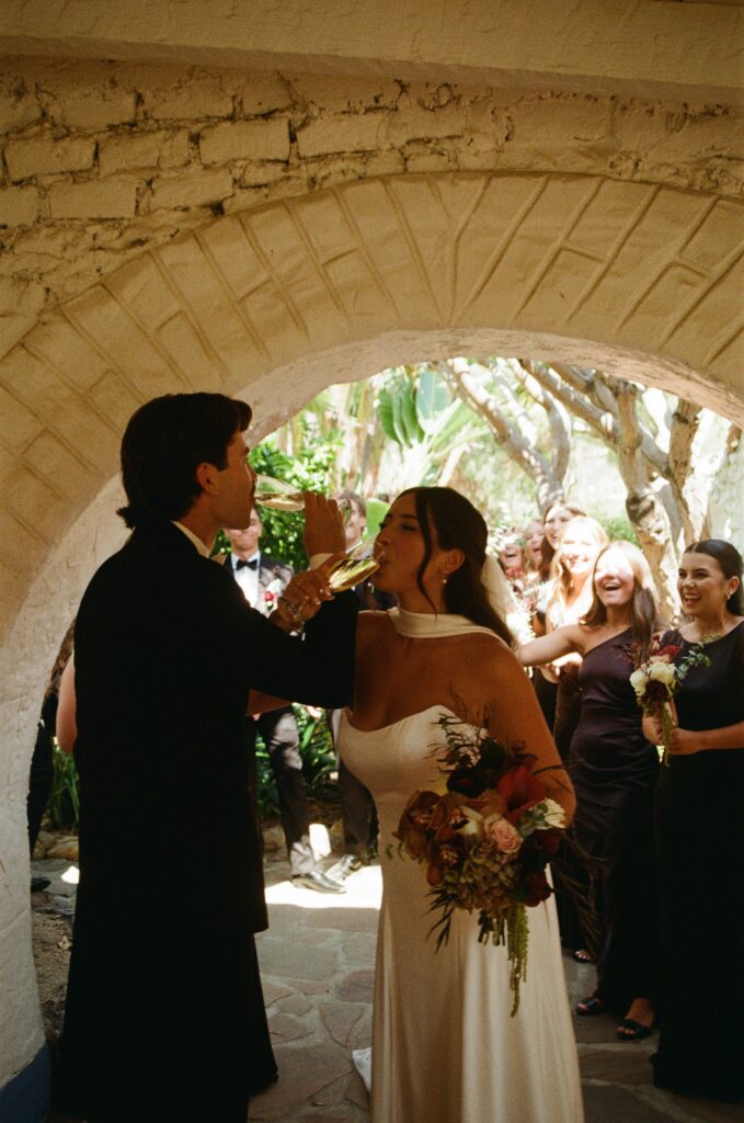 Grace and Charlie toasting with champagne after their wedding ceremony in Carlsbad, CA.