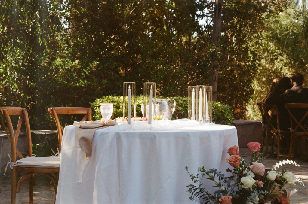 Wedding reception details with floral arrangements and decorated tables at Leo Carillo Ranch.